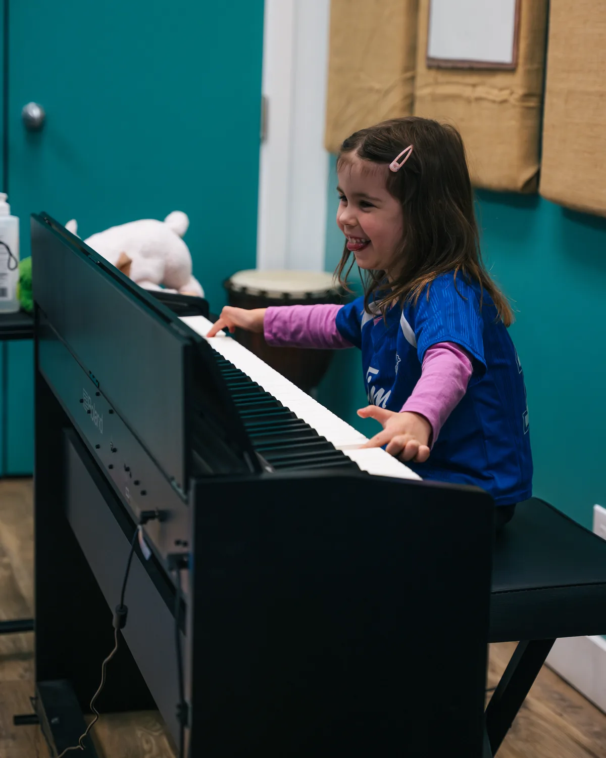 A child laughing at the piano during a Junior Jammers class at Resonate in Edmonton