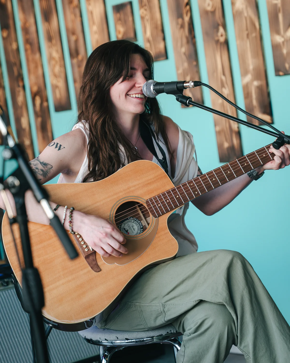 Musician singing and playing acoustic guitar in the Resonate stage room in Edmonton