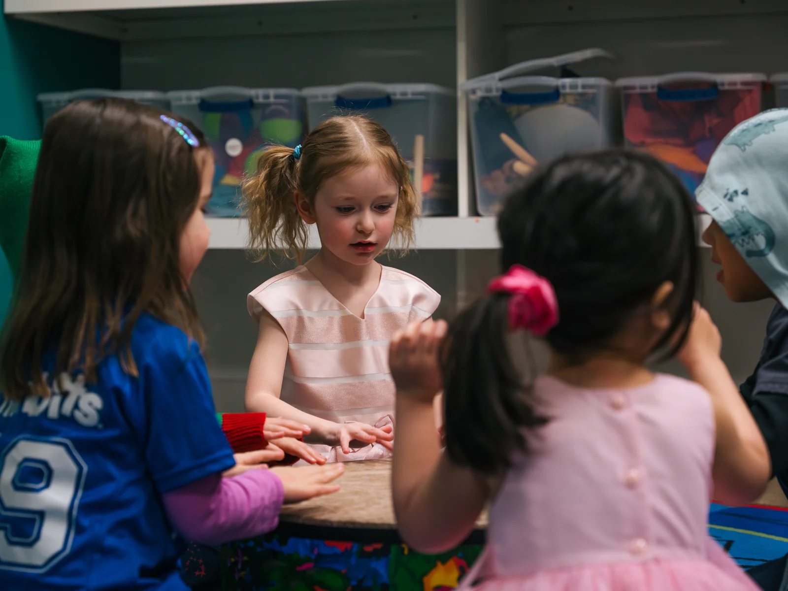 Children gathered around a hand drum in a Junior Jammers class at Resonate