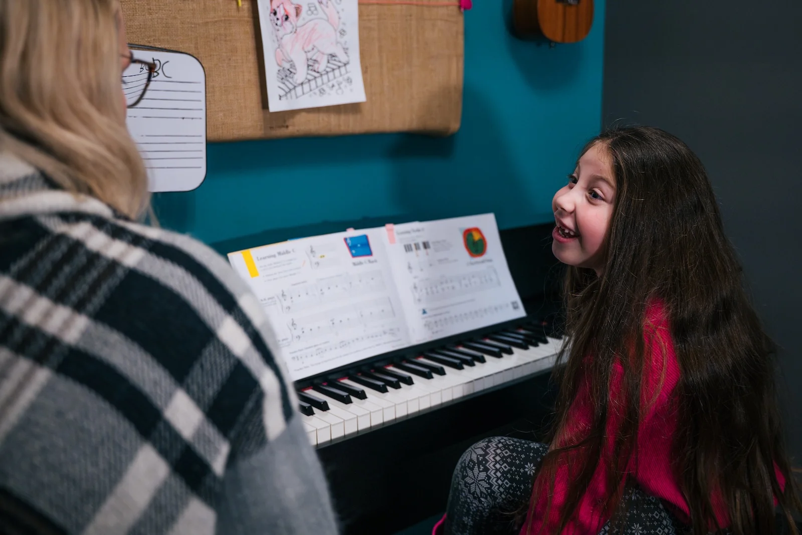 Piano teacher and student working together at the keyboard during a lesson at Resonate
