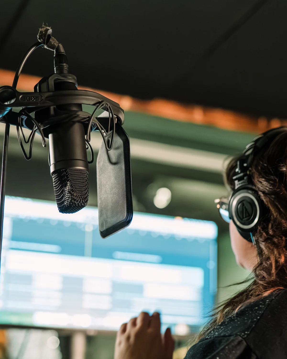 Engineer in headphones tracking at the vocal mic during a session at Resonate Music Studio