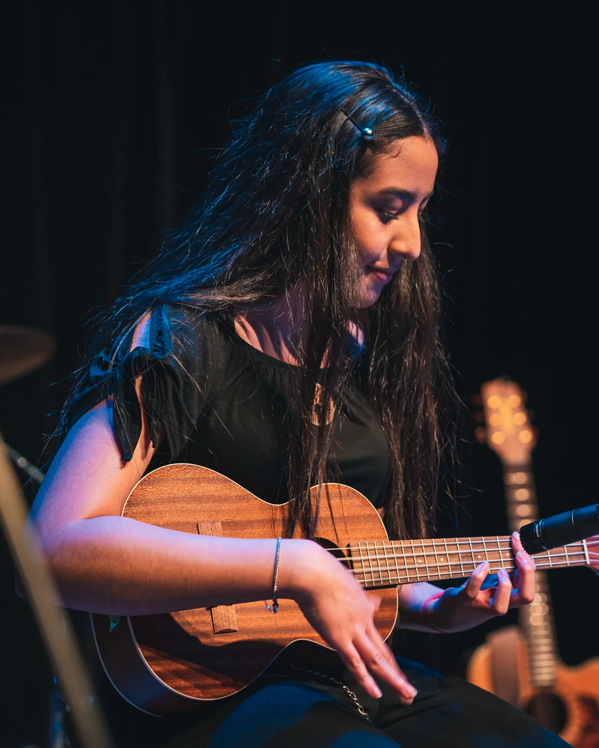 Young ukulele player performing on stage at a Resonate recital in Edmonton