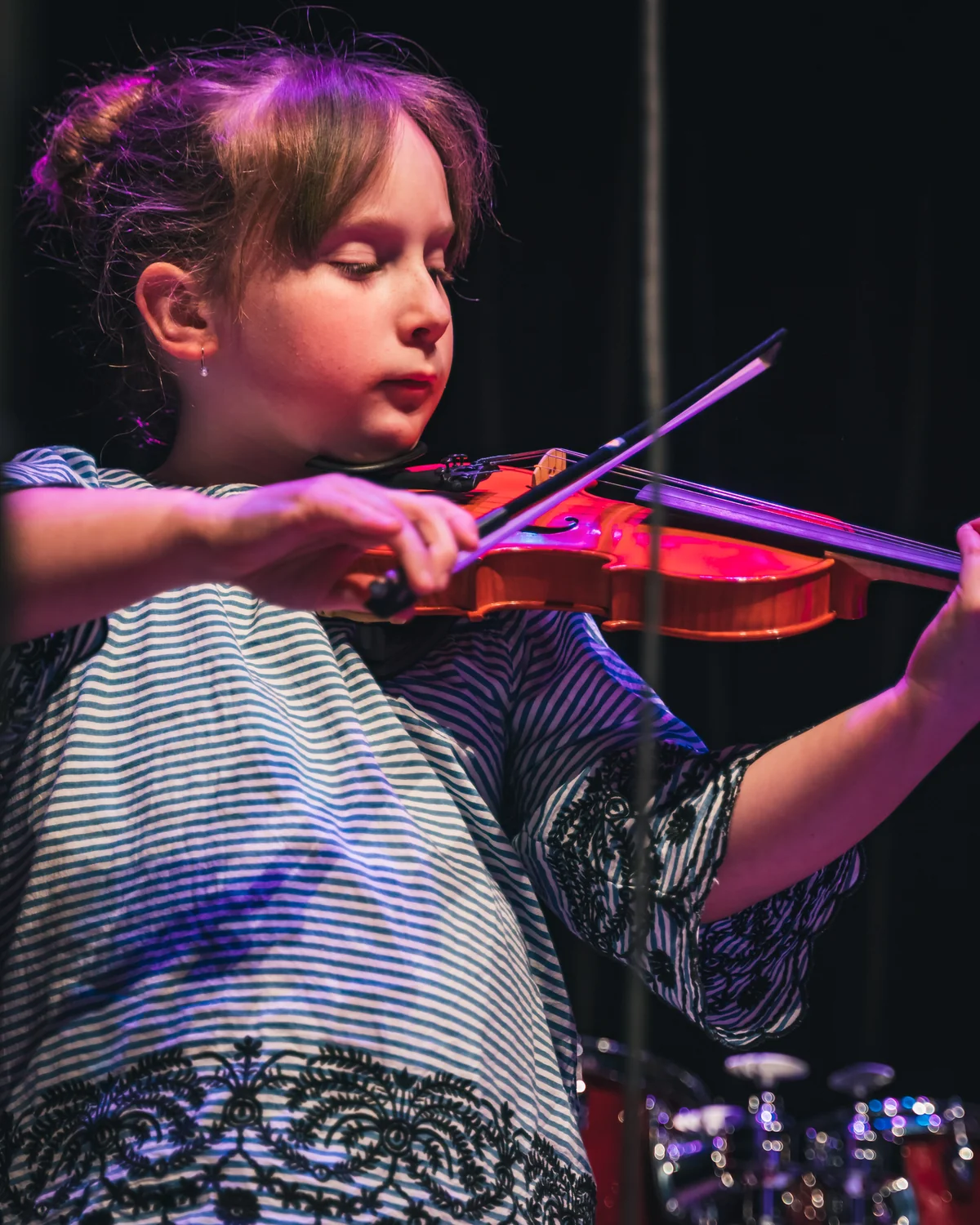 Young Resonate violin student performing on stage at a recital in Edmonton